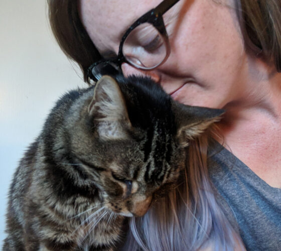 woman in glasses and kitten nuzzling