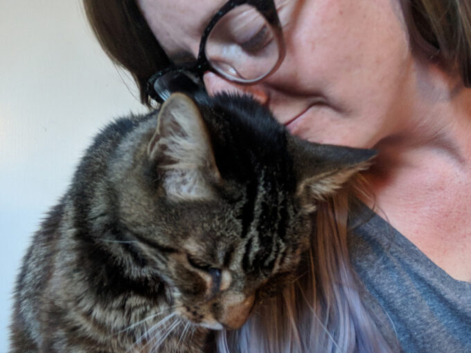 woman in glasses and kitten nuzzling